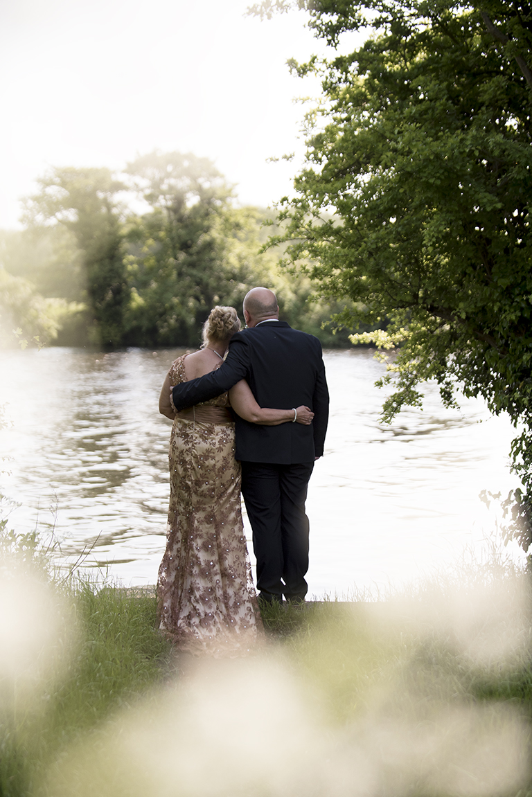Romantic moment - bride and groom having a cuddle by the river trent in nottingham