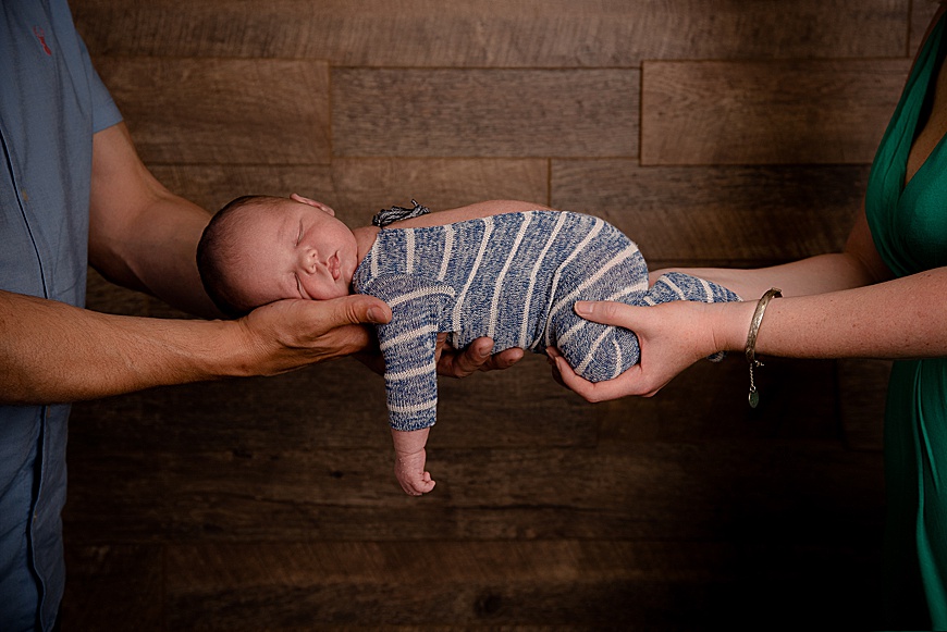 baby boy in his parents hands at his newborn session at rachael phillips photography in Mansfield, Nottinghamshire