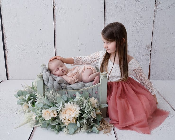 big sister looking after her sibling at a newborn session