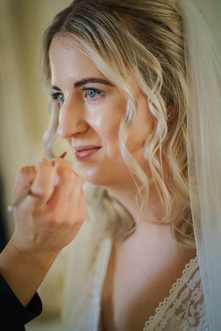 Close up of bridal getting her make up touched up during wedding preparations