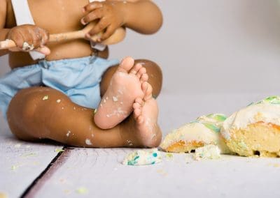Cute little boy enjoying his birthday cake at his cake smash photography session in Mansfield Nottingham at Rachael Phillips Photography studio.