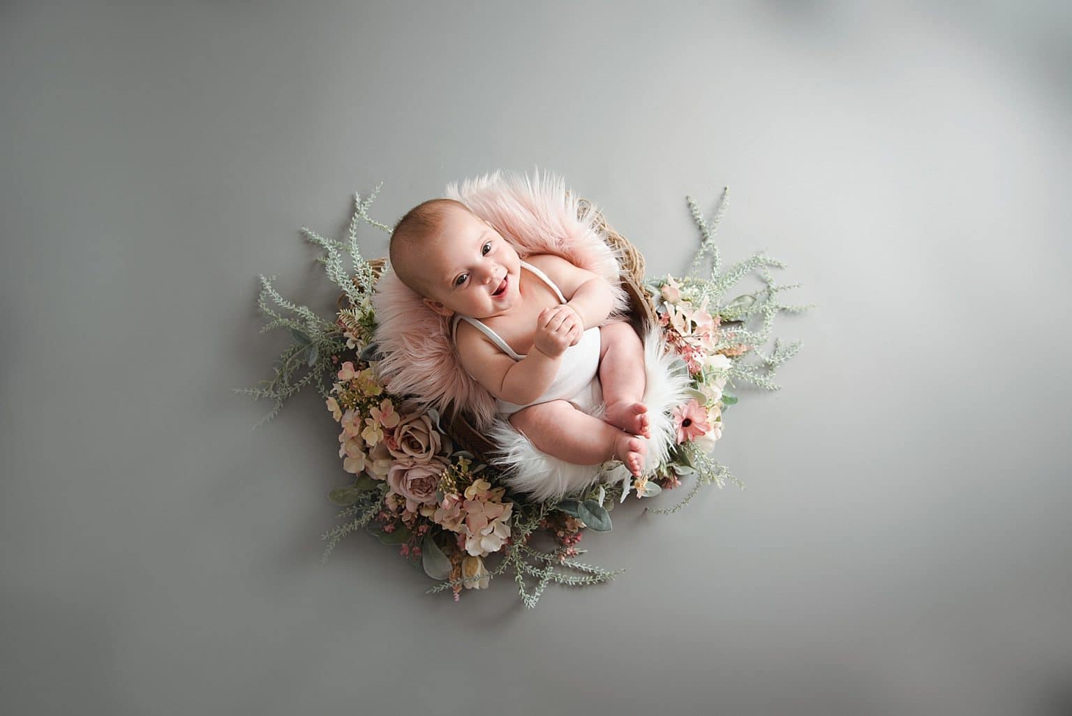 cute girl suround by flowers sat in a bucket