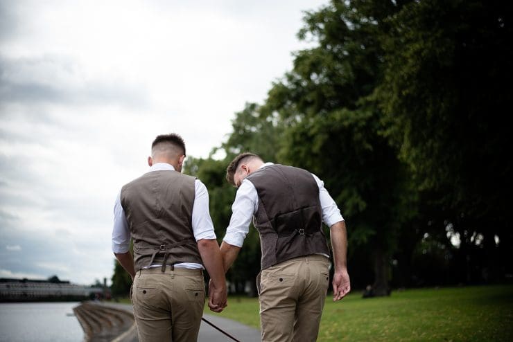 wedding Nottingham photographer - the happy couple walk along the side of the river trent hand in hand