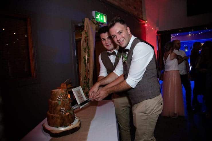 same sex couple cutting the cake
