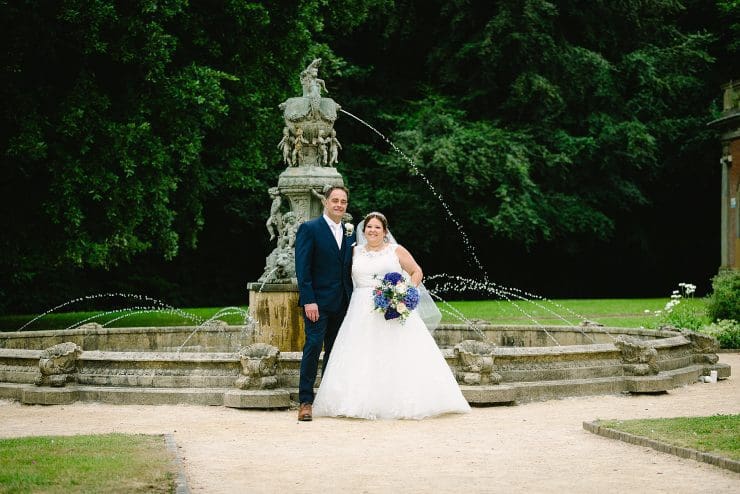 bride and groom near a fountain at Colwick hall nottingham