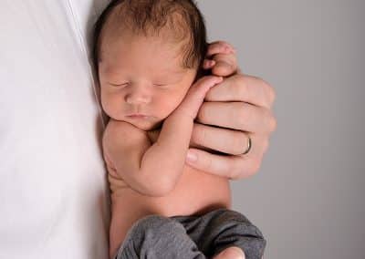 Newborn baby posing in daddys hands