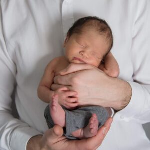 Newborn baby posing in daddys hands