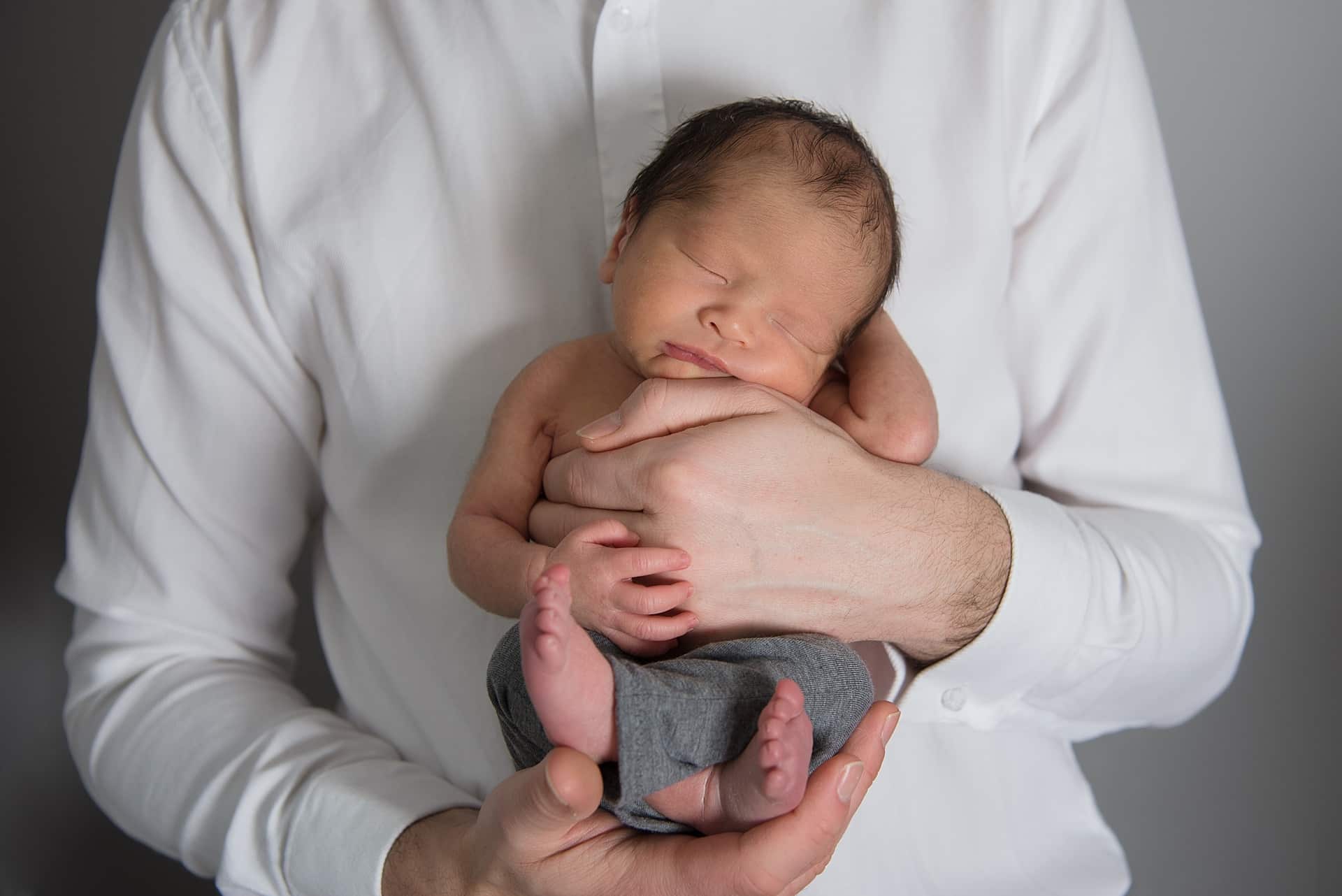 Newborn baby posing in daddys hands