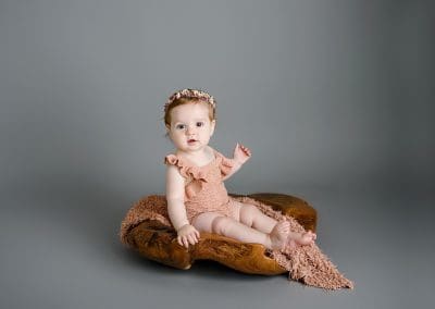 Beautiful girl sitting all on her own in a wooden bowl