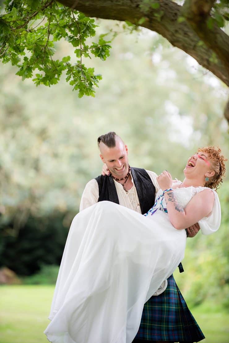 groom carrying his bride in the grounds at eastwood hall in nottingham