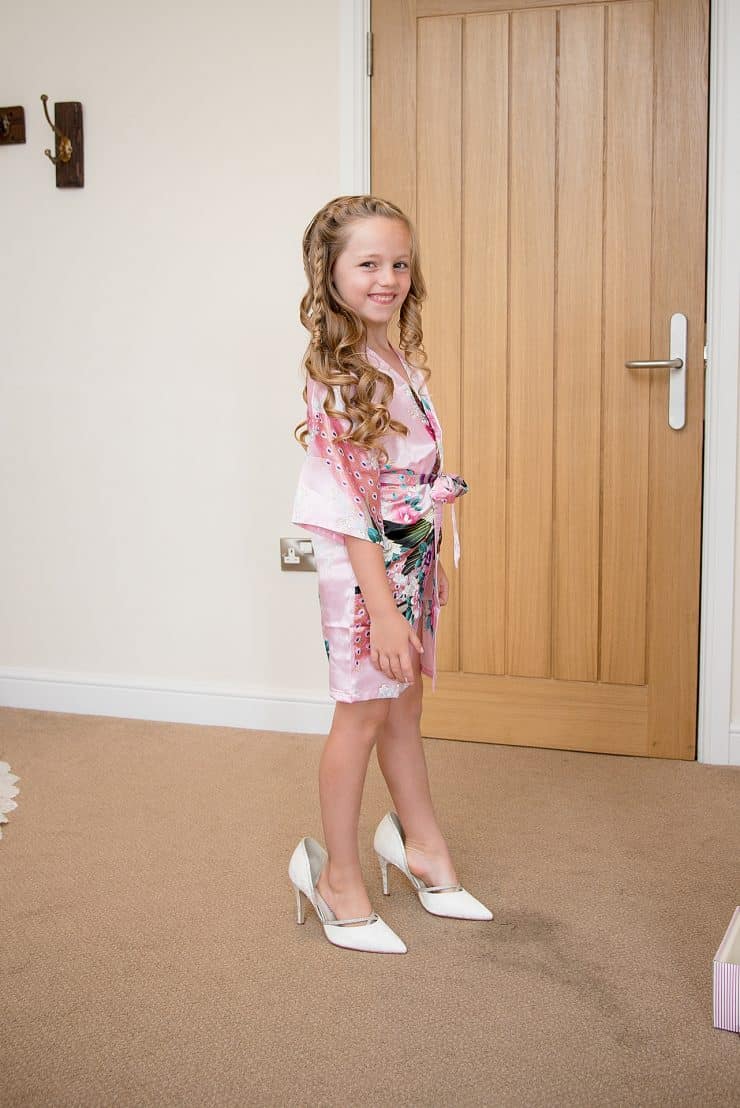 flower girl trying on mums shoes on her wedding day