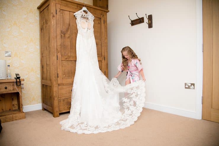 birdes daughter looking at her mums wedding dress