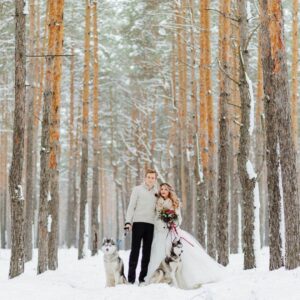 couple with there husky dogs on a snowy day