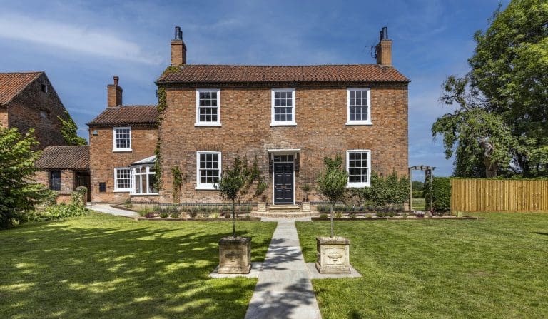 outside the guest house at the mill hoveringham in Nottingham, The wedding venue looks stunning on a lovely sunny day with blue clouds in the sky