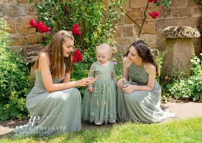 two bridesmaids with a cute little flower girl, all wearing beautiful green dresses