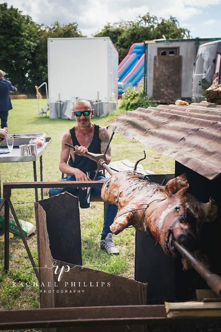 traditional home cooked hog roast. its being turned manually