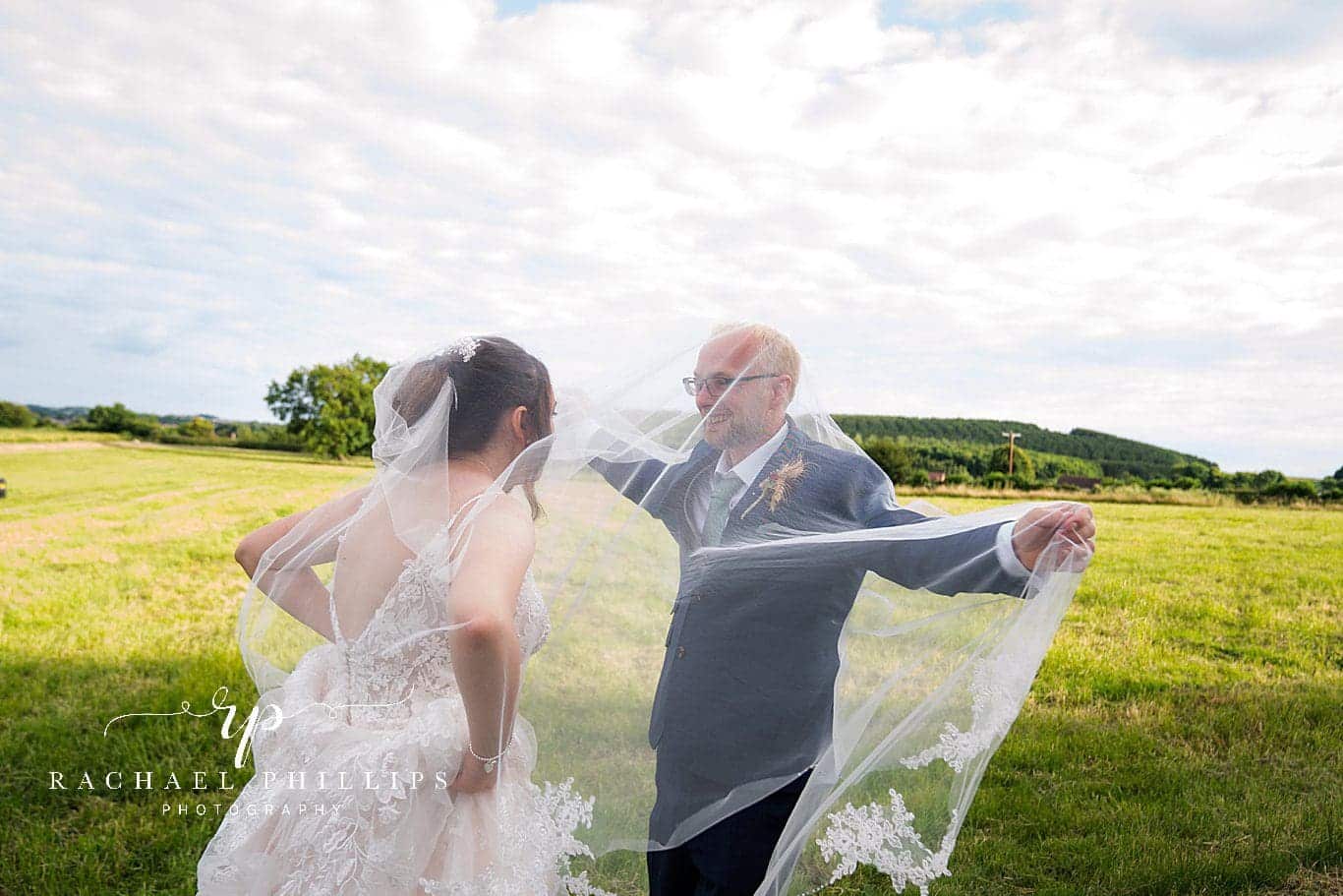 photo of the happy couple under the veil being silly on there wedding day