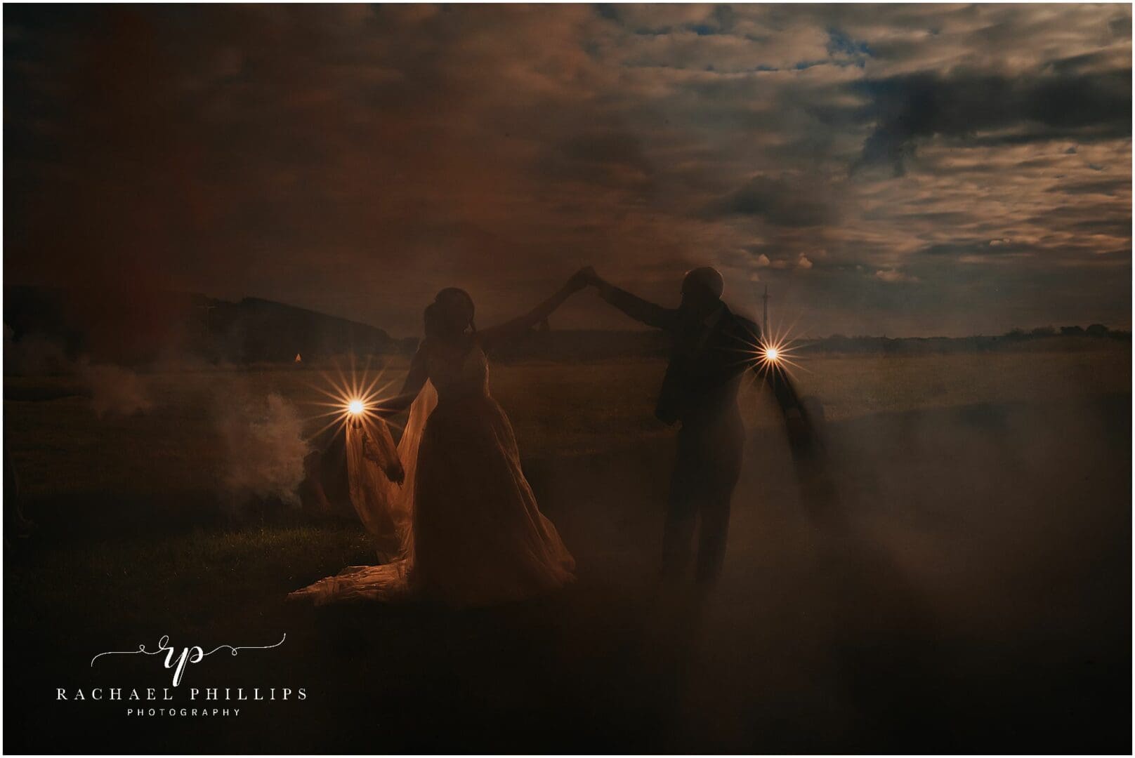 creative dark photo using smoke booms, the picture of a bride and groom dancing in the smoke on their wedding day