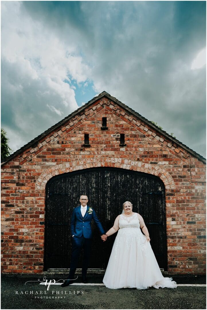 bride and groom in front of some barn doors on there wedding day