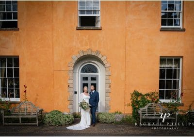 The bride and groom on there wedding day stood in the door way at Langar Hall in Nottingham