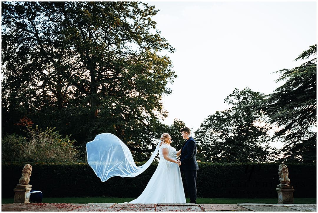Lovely couples photo outside Alfreton Hall in derby. The veil is blowing in the wind as the couples look at each other lovingly.