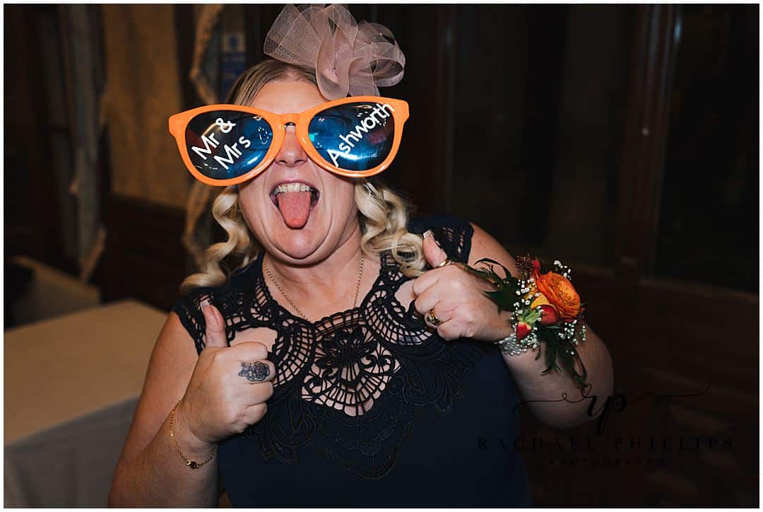Silly wedding guests wearing over sized funny glasses on the wedding day at Alfreton Hall in Derby
