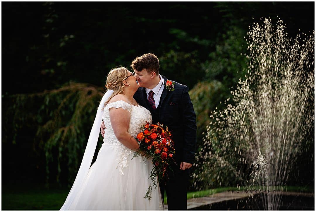 Love moment between the bride and groom in front of the fountain at Alfreton Hall in Derby