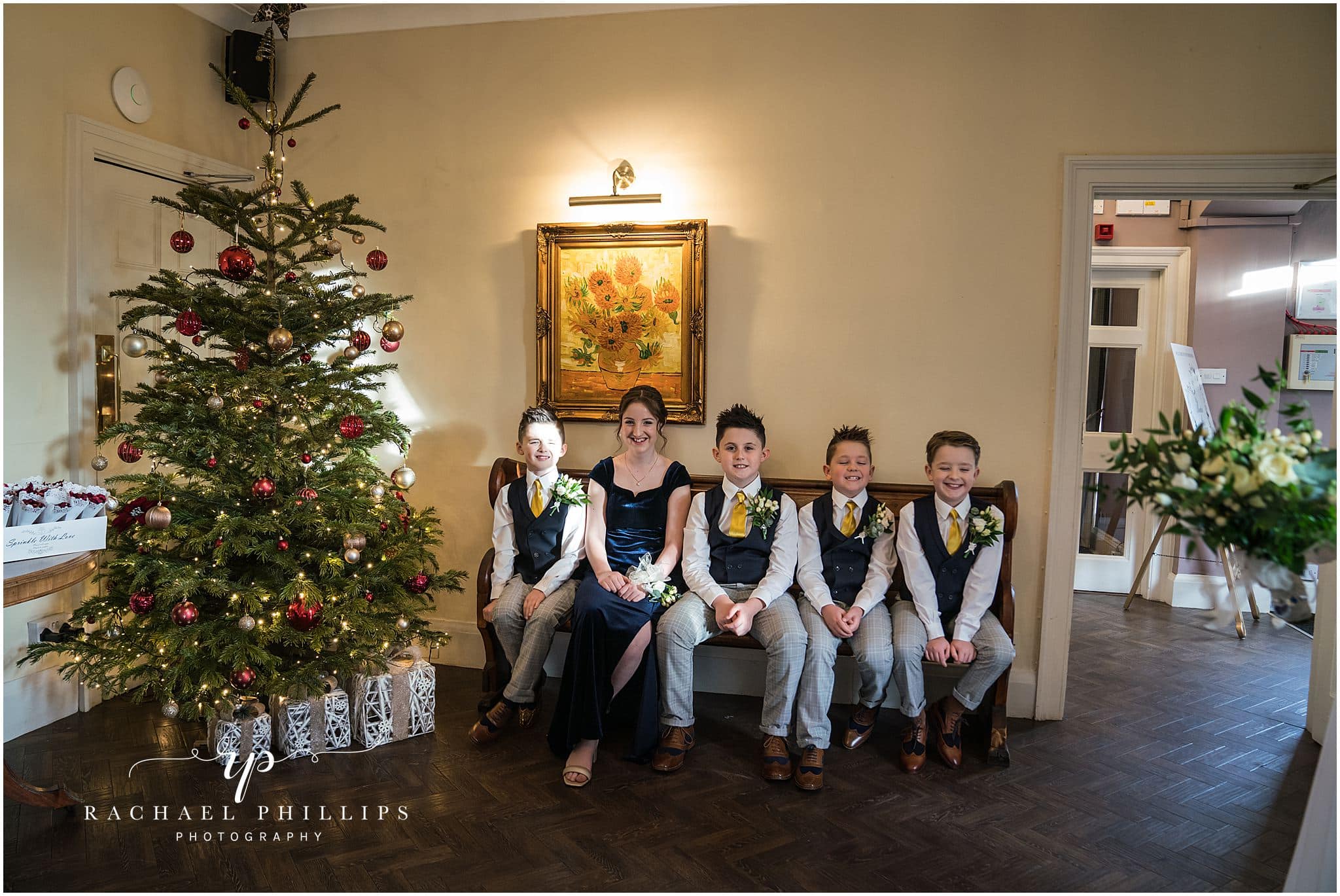 all the children are sitting by the christmas tree on the wedding day