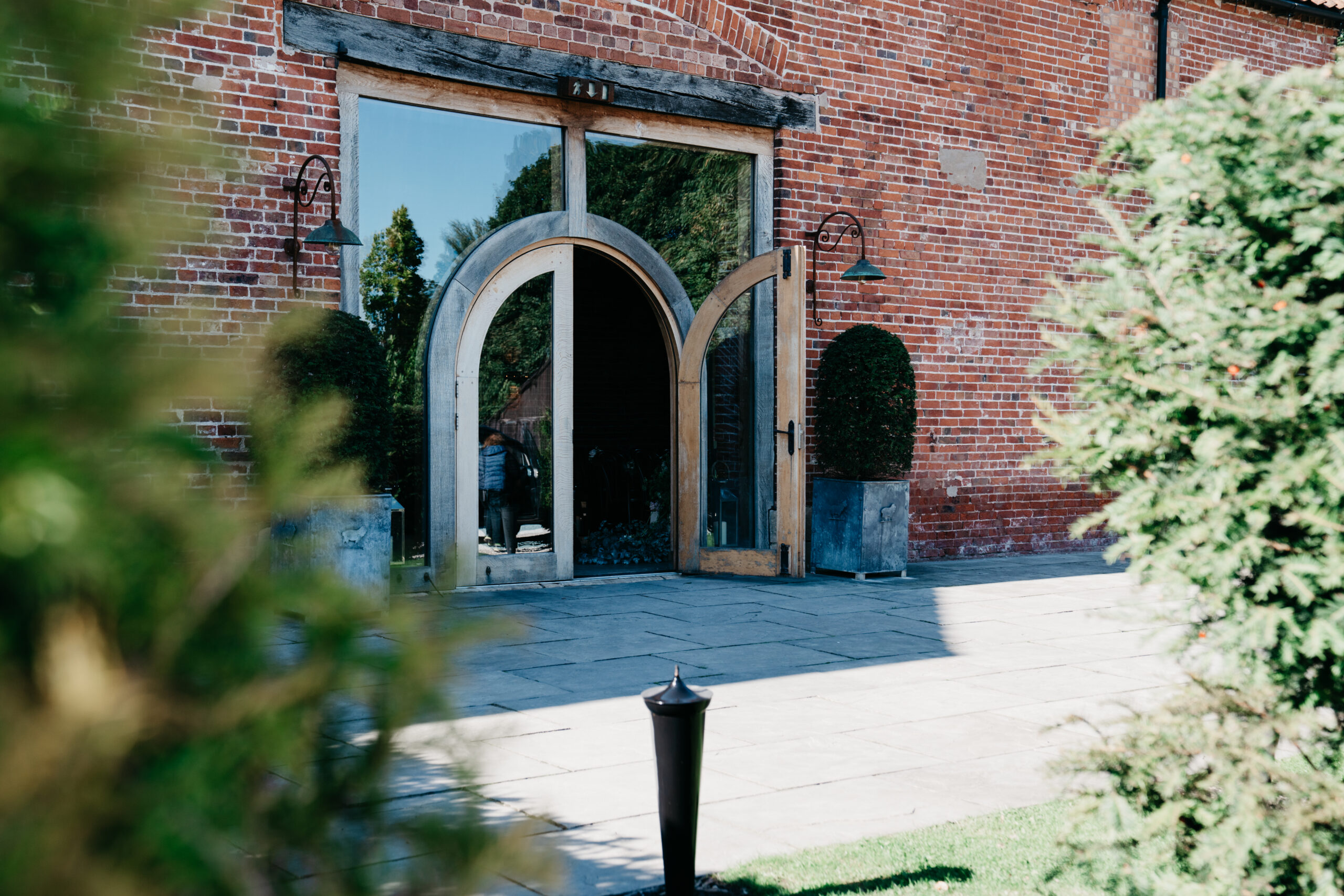 Rustic brick building with wooden arched doors.