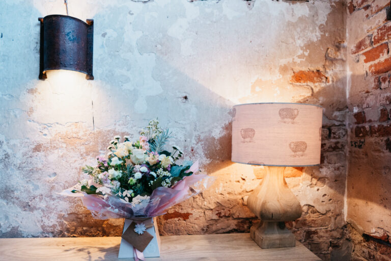 Rustic decor with flowers and table lamp on wood.