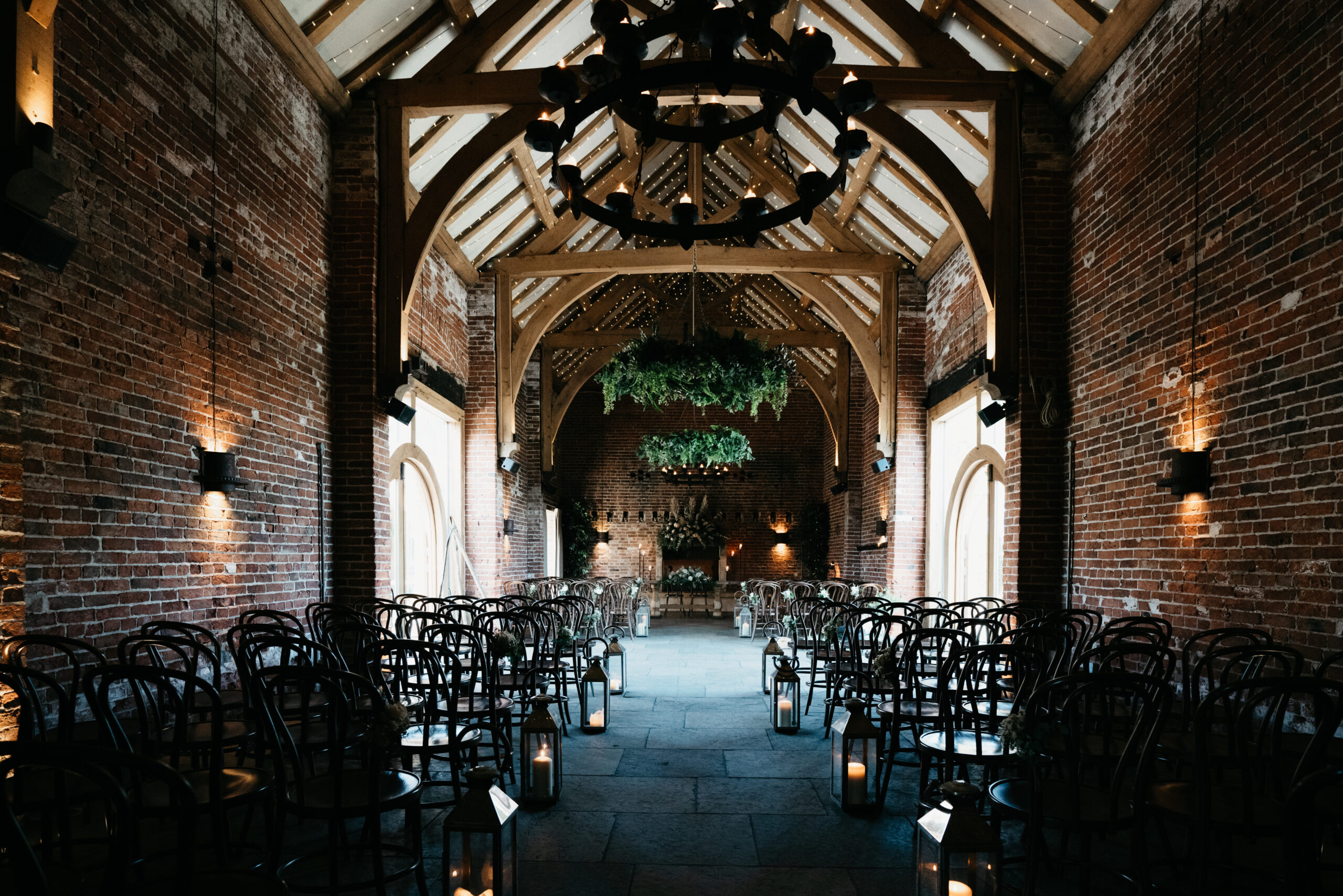 Rustic barn venue with chairs and chandeliers.