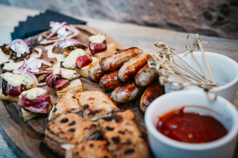 Mixed appetisers with sausages, bread, and sauce.
