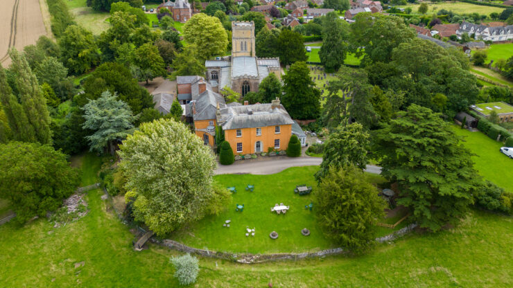 Aerial view of countryside house and churchyard.