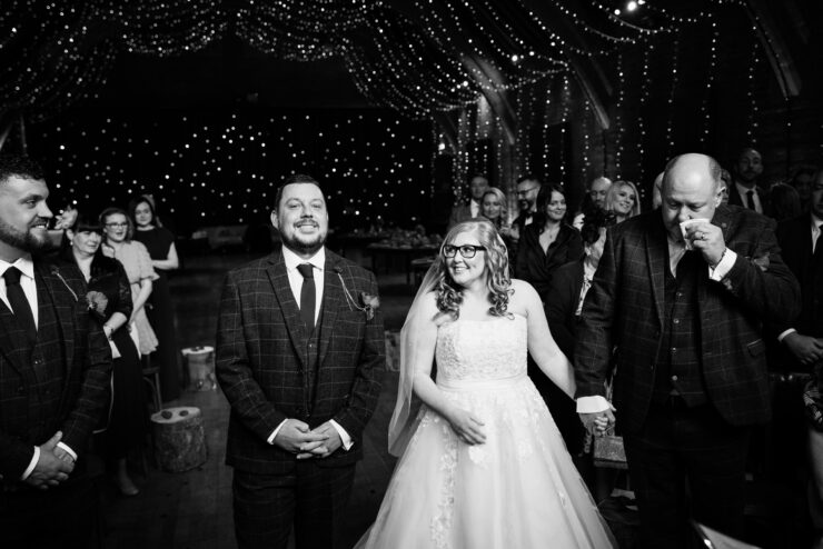 Bride smiling at wedding ceremony with guests.