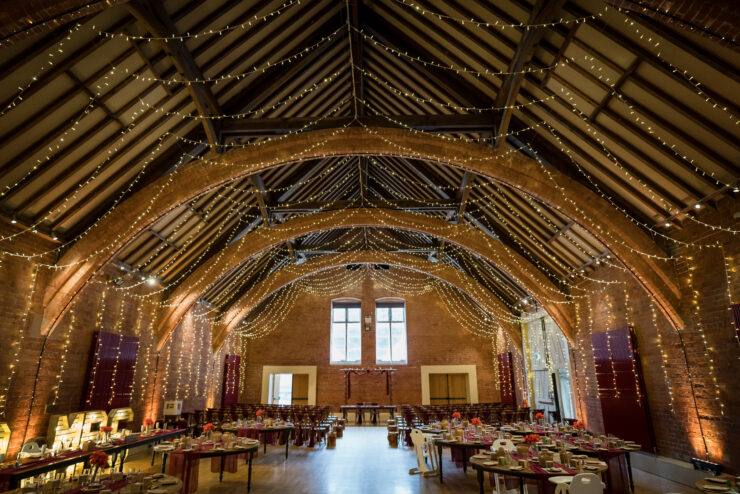 Elegant event hall with fairy lights and tables.