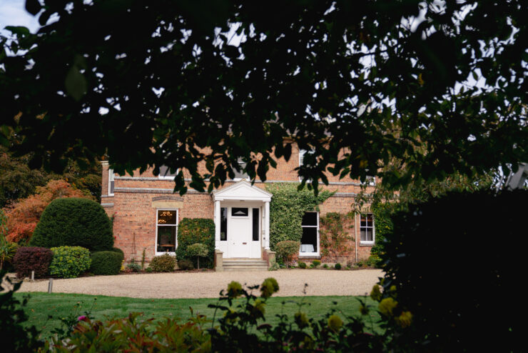 Brick house with white door and garden view.
