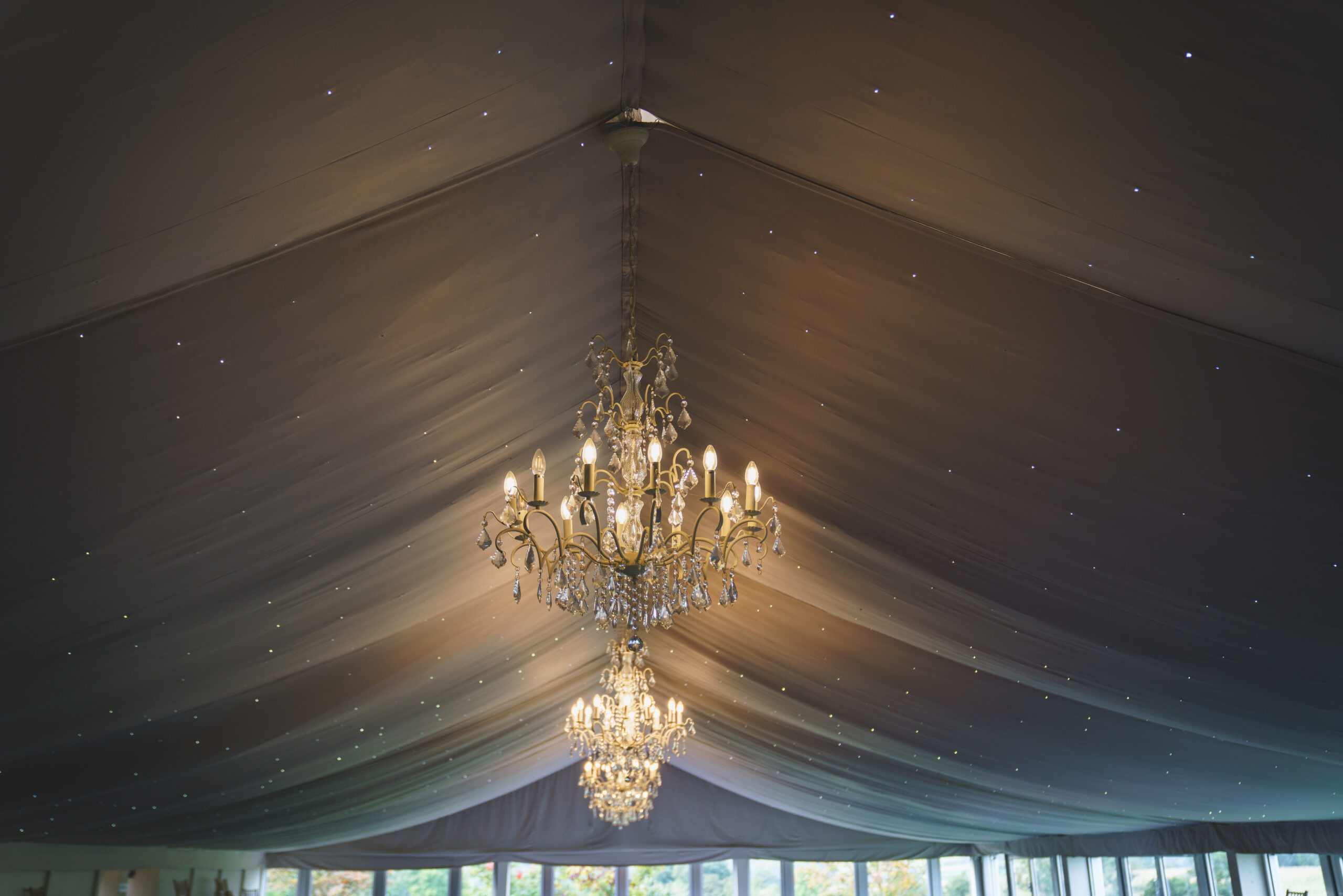 Elegant crystal chandeliers in a marquee ceiling.