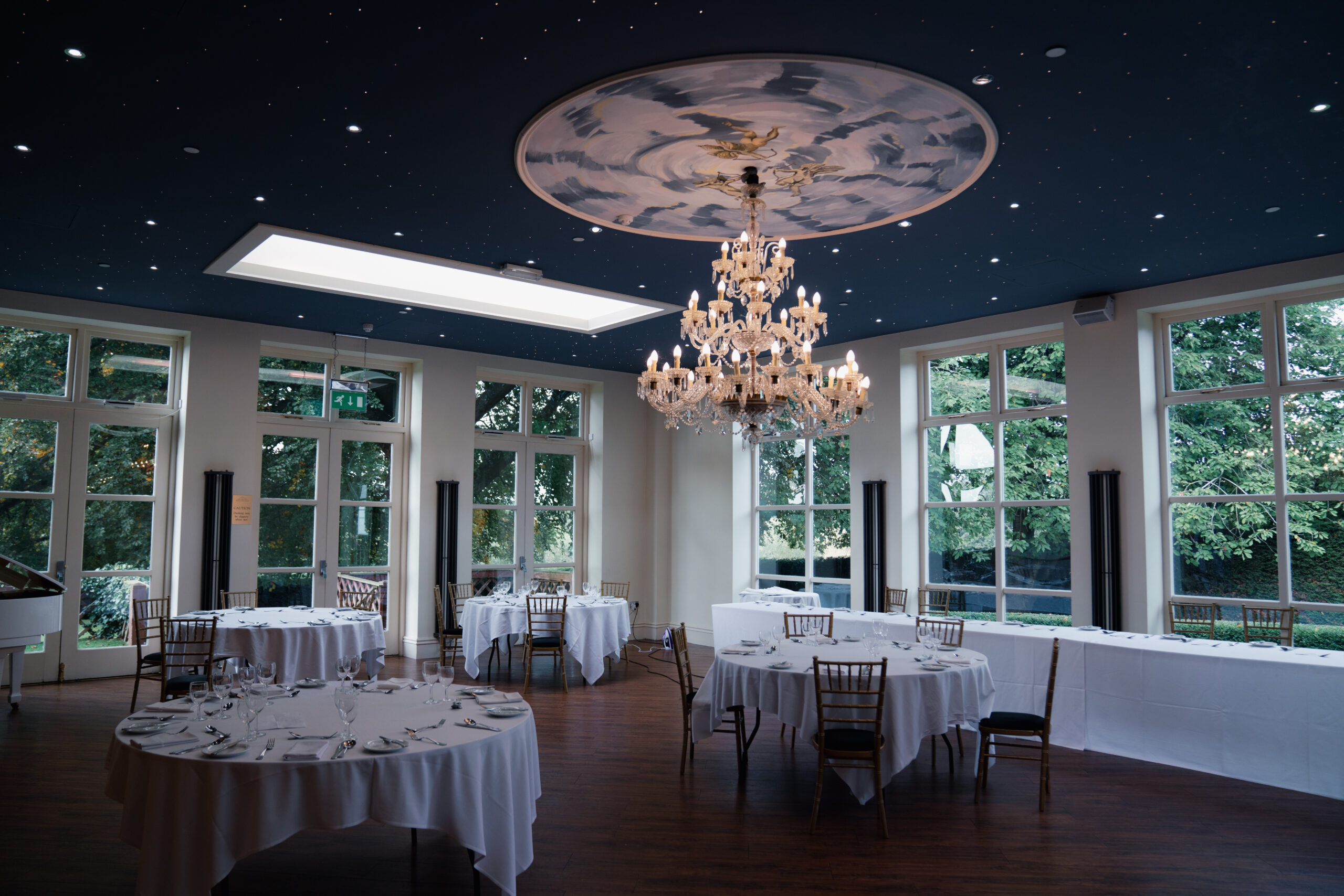 Elegant dining room with chandelier and round tables.