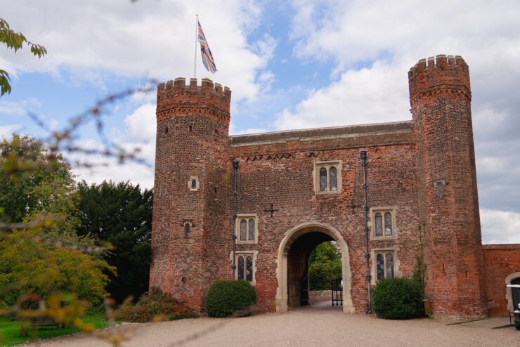 Red brick castle gatehouse with Union Jack flag.