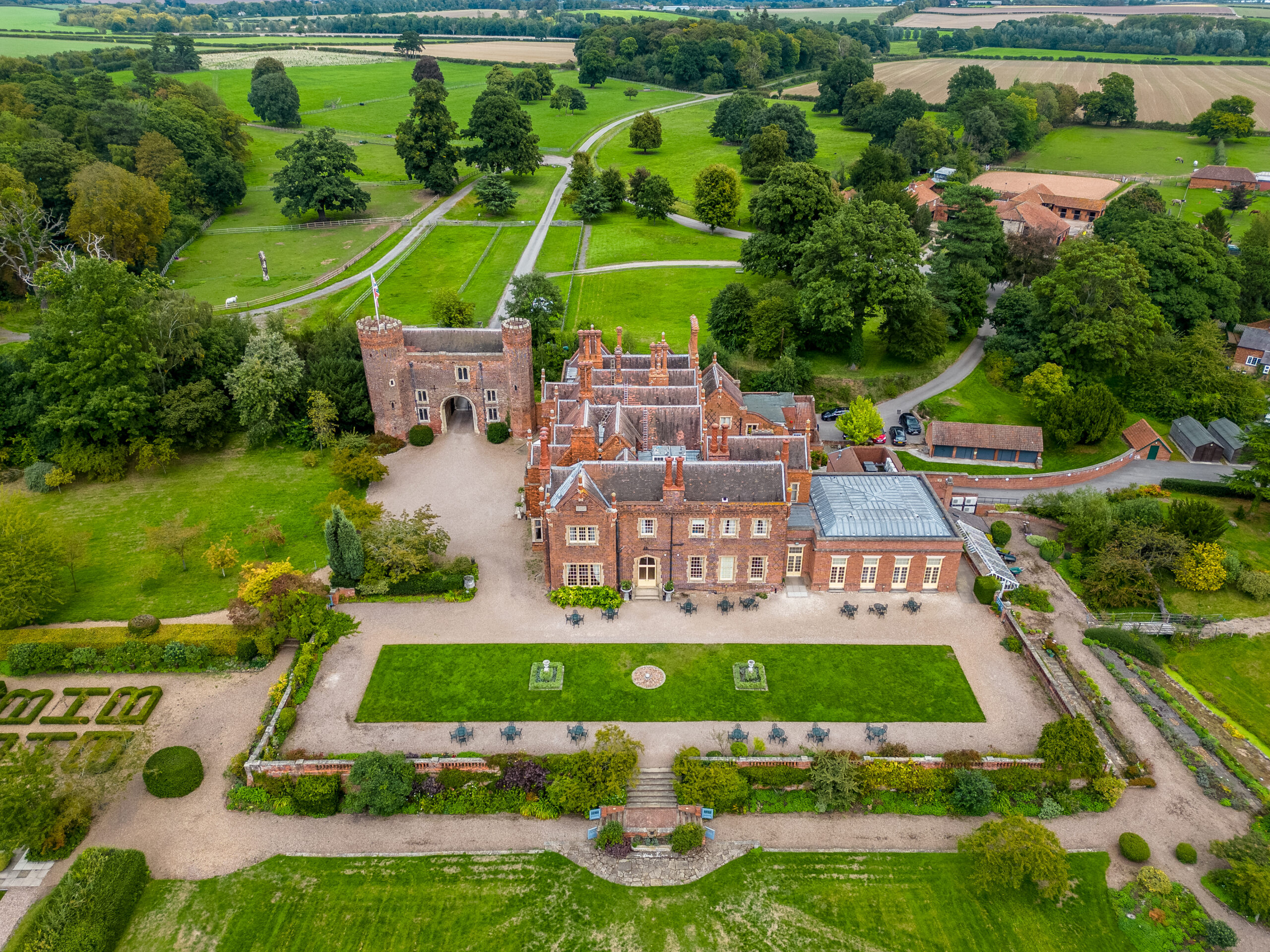 Aerial view of historic castle surrounded by gardens.