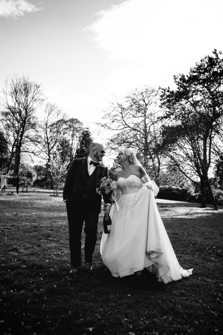 Happy couple walking on wedding day outdoors.