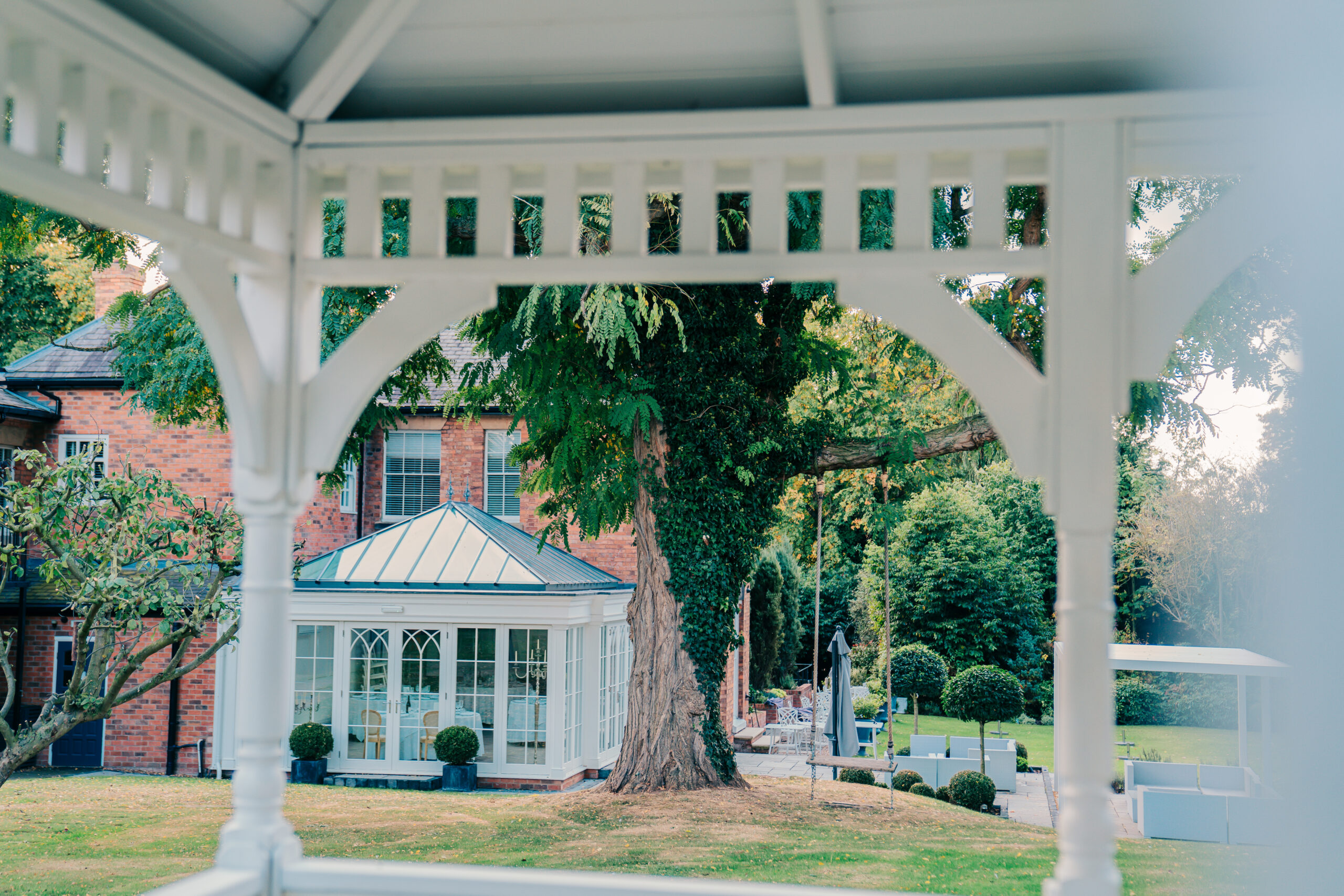 Garden view through gazebo frame and greenery