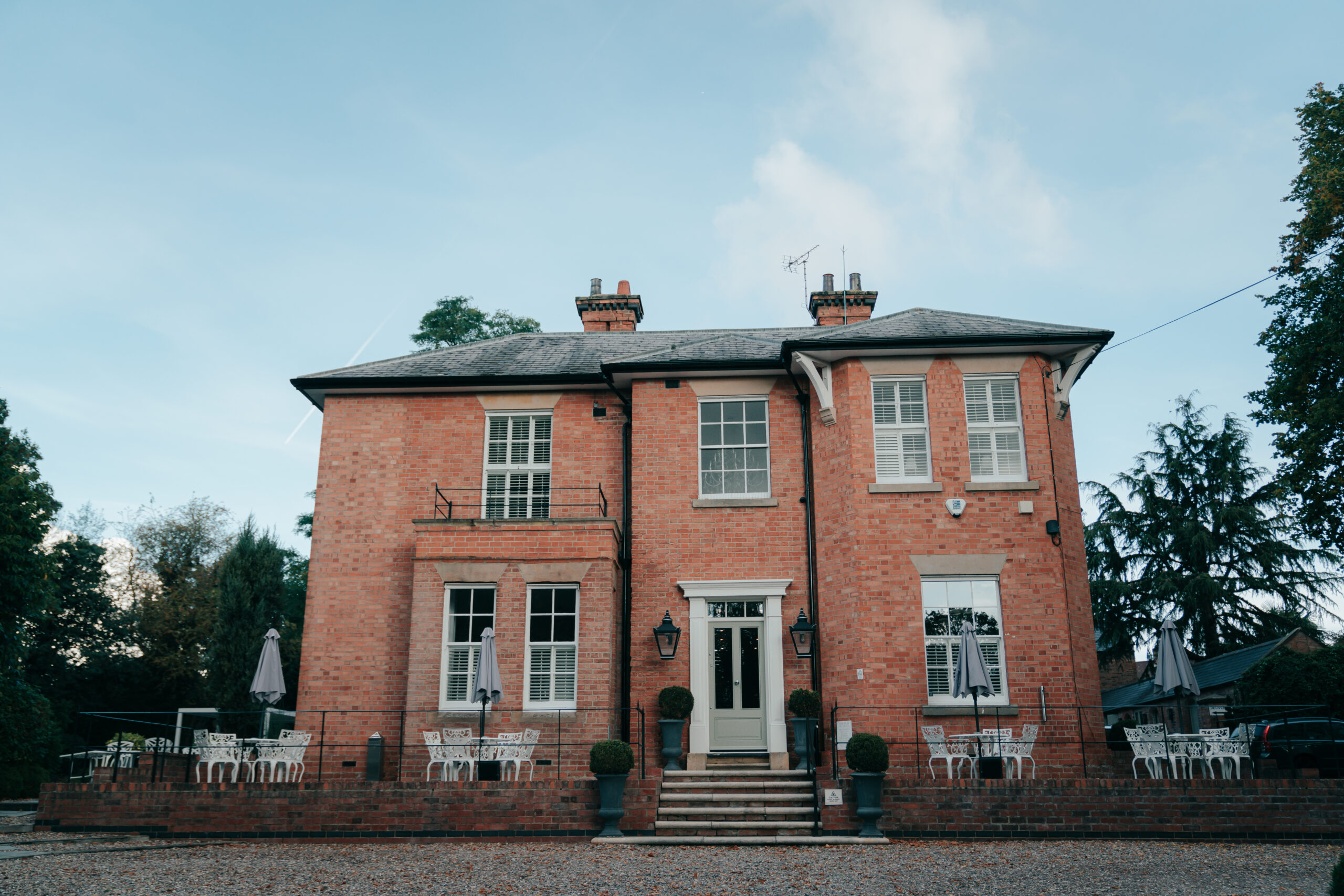 Historic brick house with outdoor seating area.