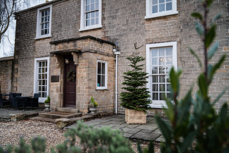 Stone house entrance with Christmas decorations.