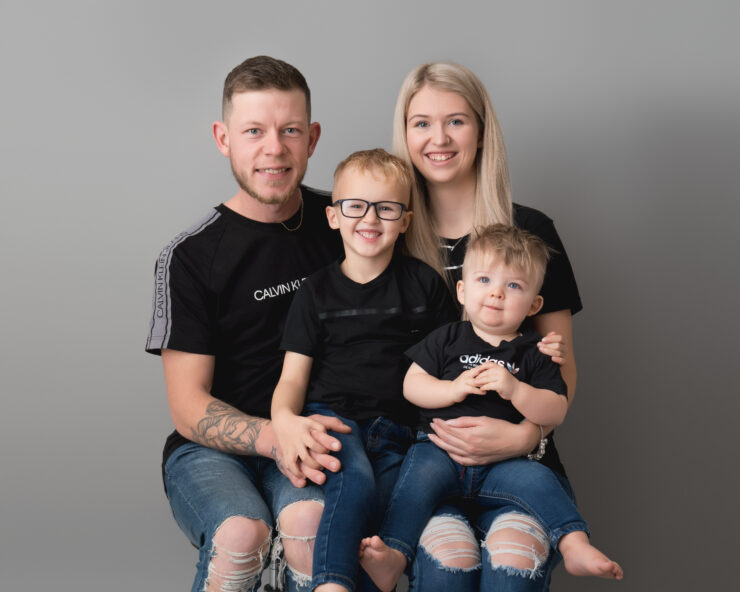 Family portrait with smiling parents and two children.