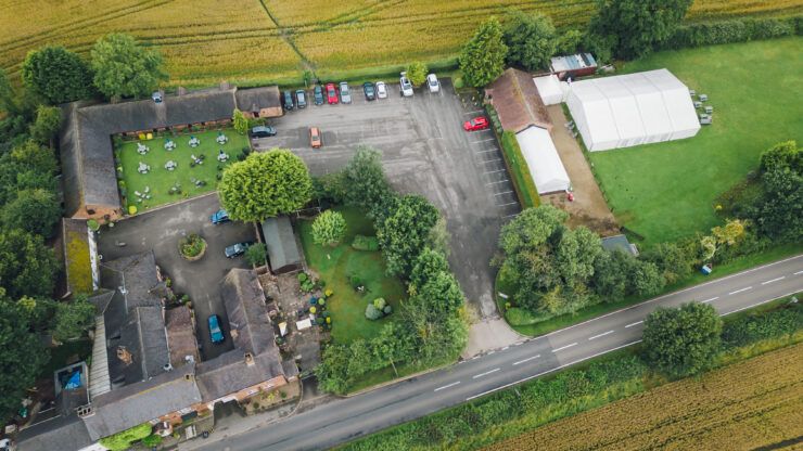 Aerial view of countryside property with parking area.