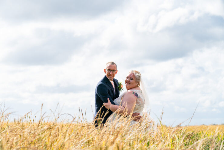 Wedding couple smiling in a sunny field