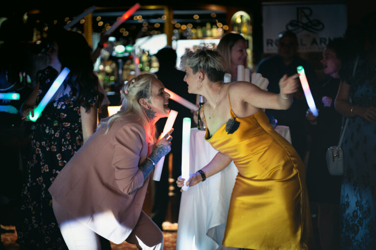 Partygoers enjoying with light sticks indoors