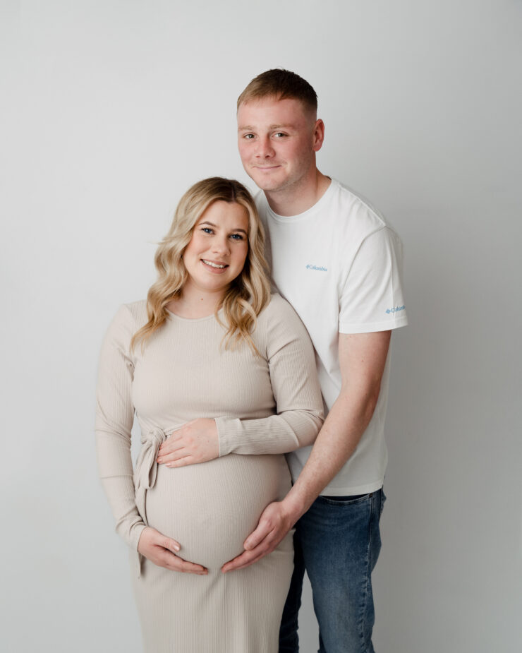 Couple smiling during maternity photoshoot