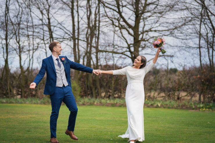 Bride and groom celebrating outdoors in garden.